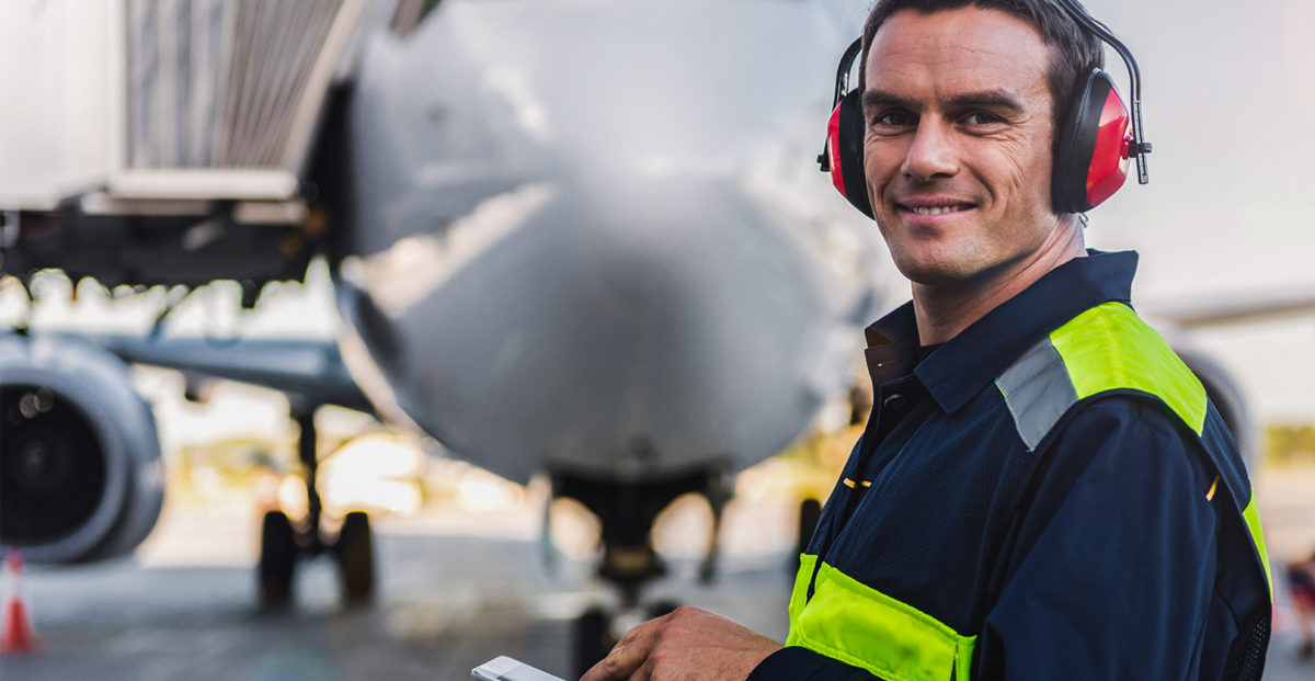 Airline worker standing in front a plane