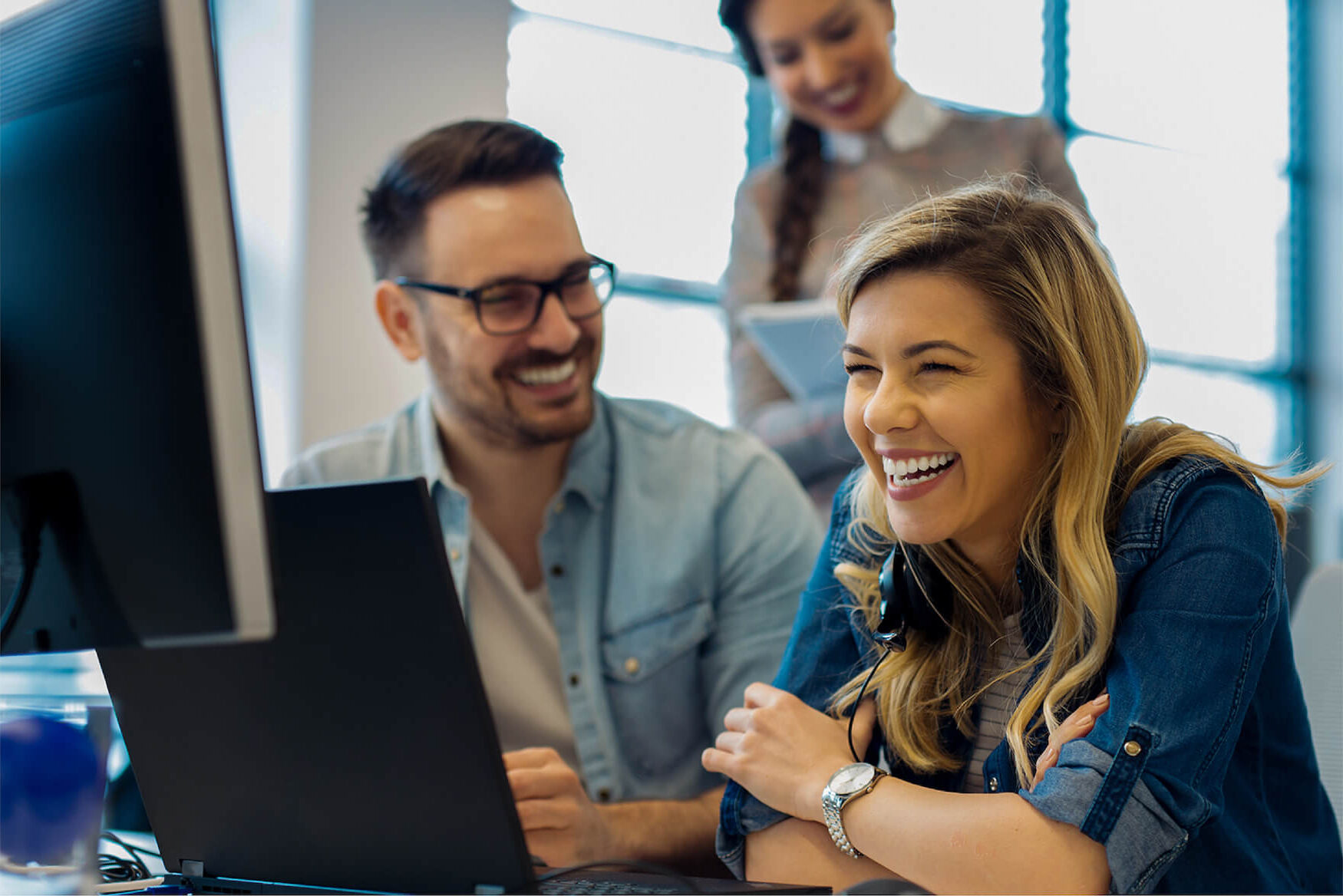 People laughing at their desk